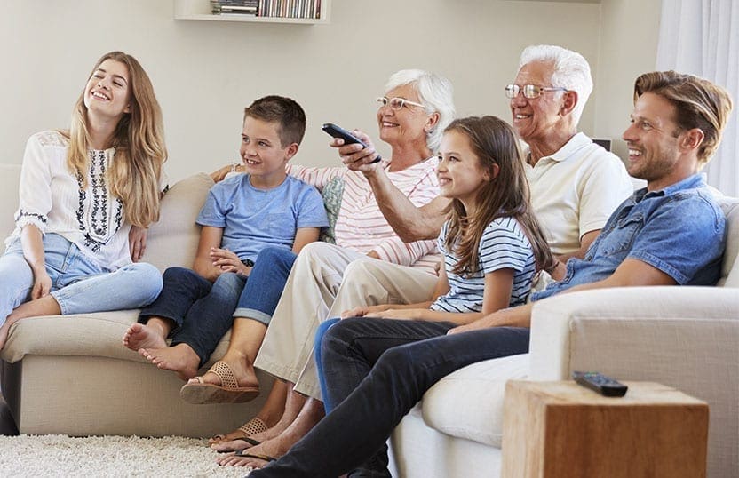 Family watching television in the living room