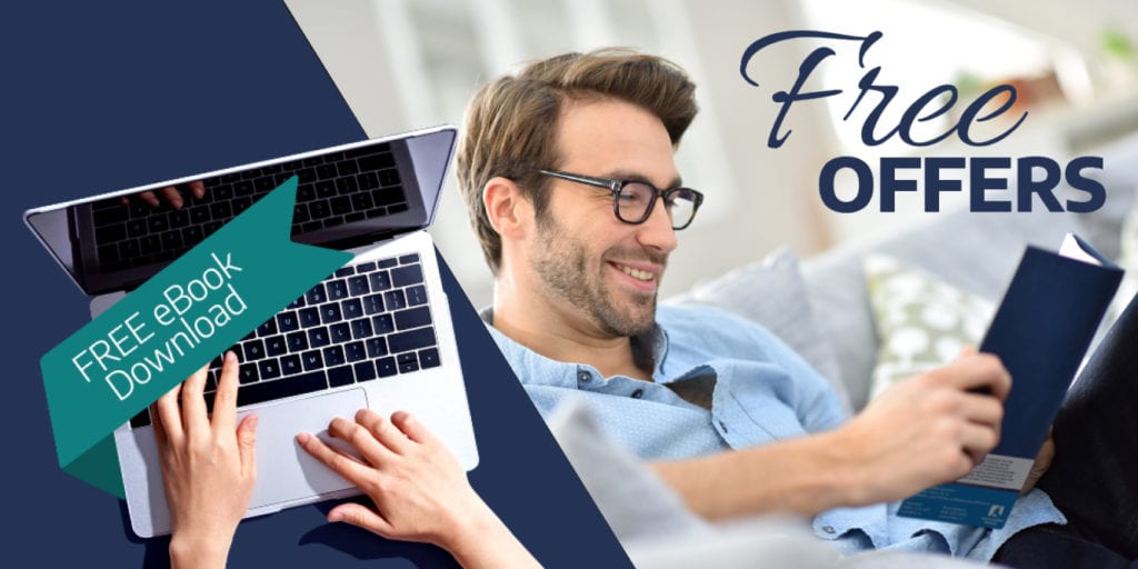 Man reading a book while opening the laptop
